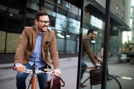 Young businessman riding on his bicycle. Going everywhere by his bikeの写真素材