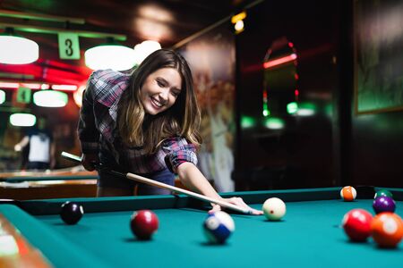 Young happy girl having fun with billiard. Play and fun concept.の写真素材