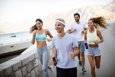 Outdoor portrait of group of friends running and jogging in nature