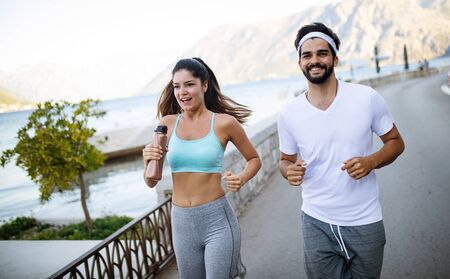 Happy fit people couple jogging and running outdoorsの写真素材
