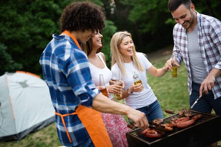 Group of happy friends having a barbecue party in natureの写真素材