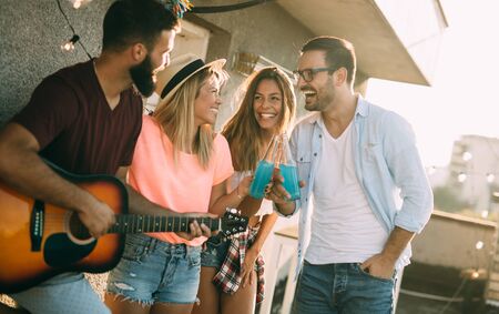 Group of happy friends having party on rooftopの写真素材