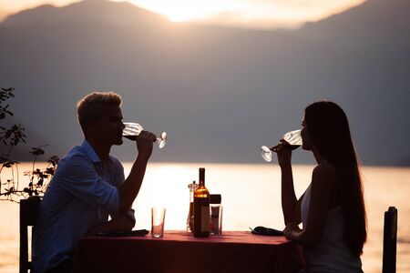 People, vacation, love and romance concept. Young couple enjoying a romantic dinner on beach.の写真素材