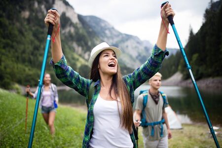 Group of friends hikers walking on a mountain at sunsetの写真素材