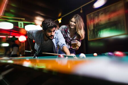 Couple dating, flirting and playing billiard in a pubの写真素材