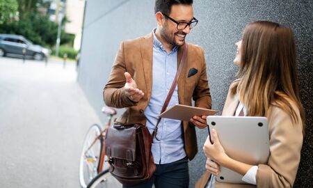 Portrait of happy smiling business people talking in the city