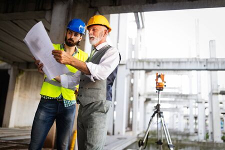 Team of architects and engineer in group on construciton site check documents and business workflowの写真素材