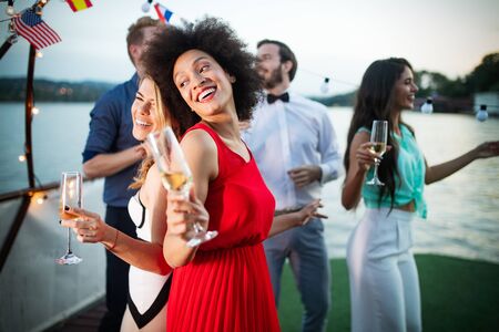 Group of friends drinking, chatting and having a fun at outdoor partyの写真素材