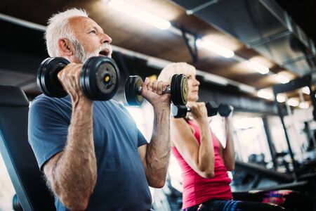 Happy senior people doing exercises in gym to stay fitの写真素材