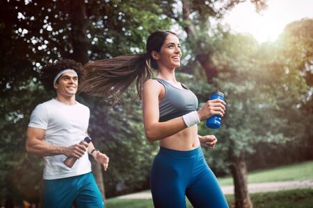 Happy young people jogging and exercising in natureの写真素材
