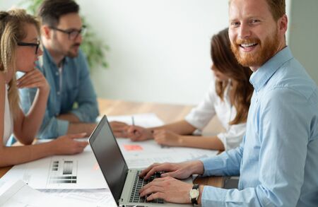 Group of business people working and communicating while sitting at the office desk together