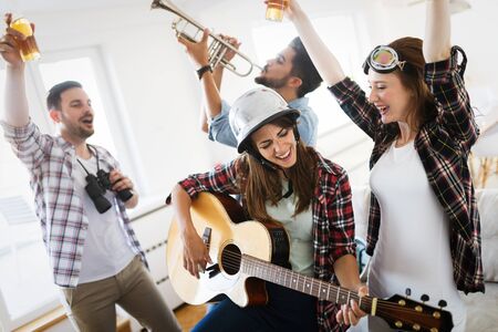 Small group of young people hang out at the house party, friends having funの写真素材