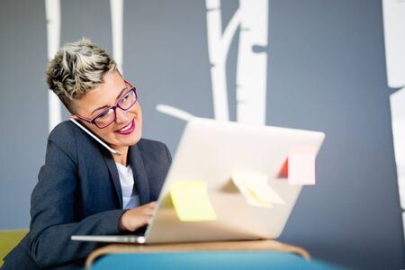 Attractive young female architect working on laptop