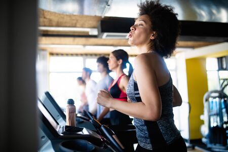 Group of young people running on treadmill in gymの写真素材