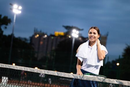 Fit woman tennis player with injury on a clay tennis court