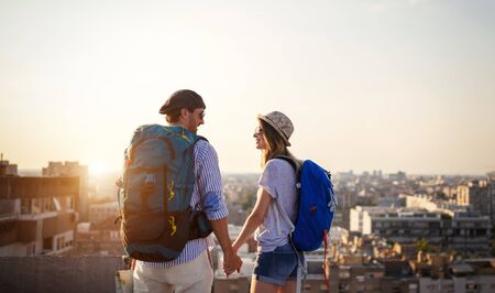 Happy young couple of travellers holding map and having funの写真素材