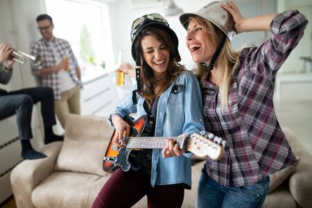Cheerful friends having party together and playing instrumentsの写真素材