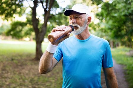 Attractive retired man with a nice smile jogging in parkの写真素材