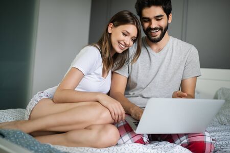 Young couple relaxing with laptop at home. Love,happiness,people and fun concept.