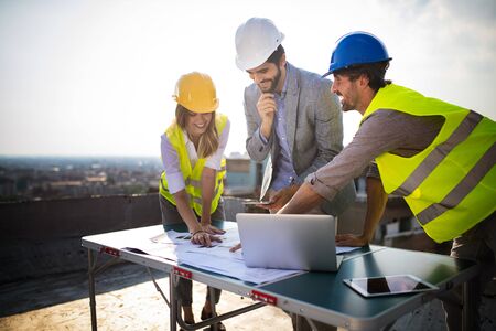 Team of architects people in group on construciton site check documents and business workflow.の写真素材
