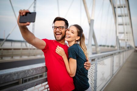 Sport man and woman making selfies. Happy couple hugging and posing for camera