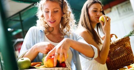 Young women shopping on the market healthy vegetables and fruitsの写真素材