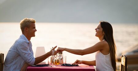 Couple sharing romantic sunset dinner on the beachの写真素材