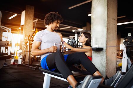 Fitness instructor exercising with client at the gym.