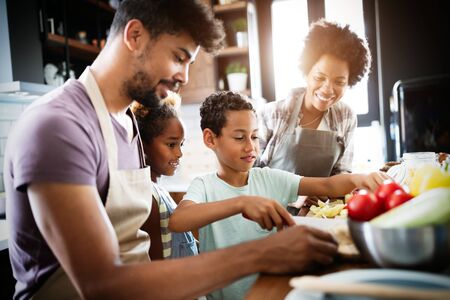 Happy family preparing healthy food in kitchen togetherの写真素材