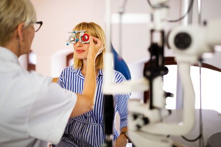 Optometrist examining patient in modern ophthalmology clinicの写真素材