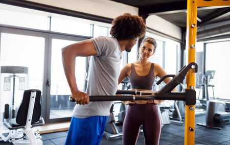 Happy fit friends exercising, working out in gym to stay healthy together