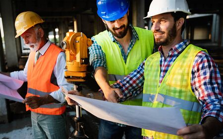 Male architects analyzing blueprint at construction site