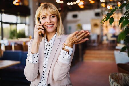 Beautiful brunette coworker businesswoman talking on mobile phoneの写真素材