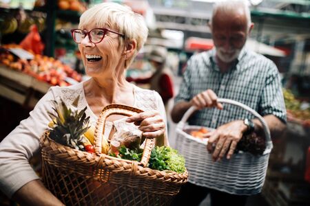 Mature couple shopping vegetables and fruits on the market. Healthy diet.の写真素材