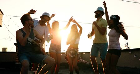 Group of friends having fun at rooftop party.の写真素材