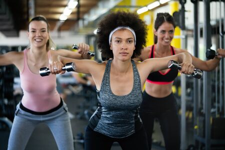 Group of healthy fit people at the gym exercising