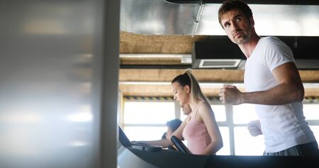 Group of young people exercising on a treadmill at gymの写真素材