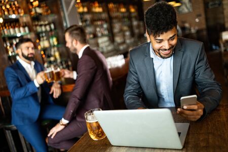 Handsome young business man, blogger or remote working with laptop in barの写真素材
