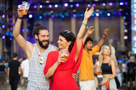 Happy young group of friends attending festivals at summerの写真素材