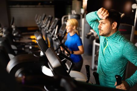 Exhausted athlete man working out in gymの写真素材
