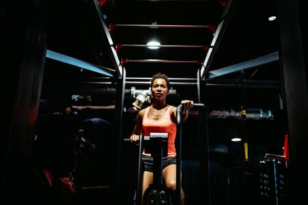 Fitness female using air bike for cardio workout at crossfit gym.の写真素材