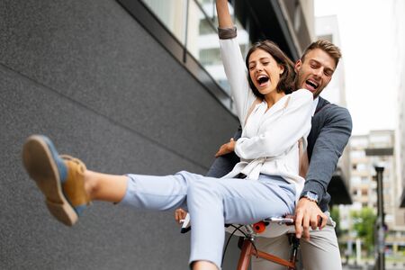 Close up of loving couple having fun and riding on bike in the cityの写真素材