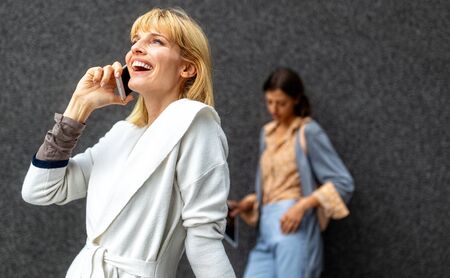 Portrait of a smiling beautiful woman with phone, smartphone outdoor