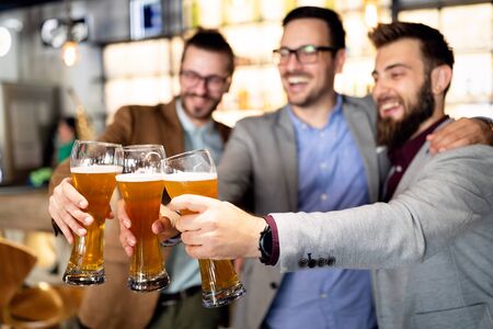 Business people drink beer after work in pub. Businessmen enjoy a beer.の写真素材