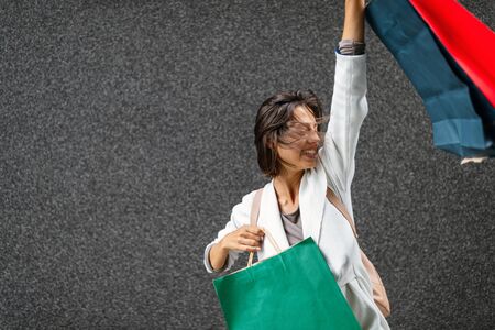 Portrait of beautiful smiling young woman with shopping bagsの写真素材