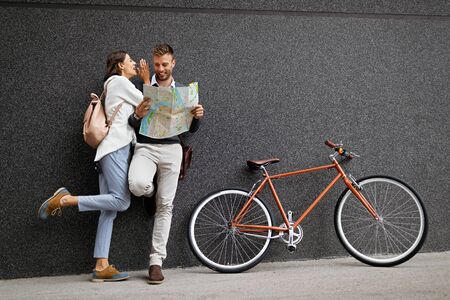 Holidays, dating and tourism concept. Smiling couple in love with map in the cityの写真素材