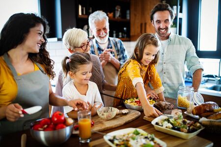 Grandparents, parents and children spending happy time in the kitchenの写真素材
