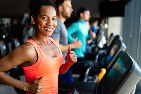 Happy woman smiling and working out in gymの写真素材