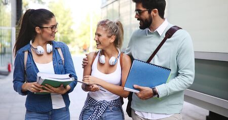 Group of happy college students studying at campus library together