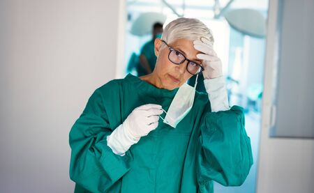 Mature woman surgeon tired after an operation in hospital